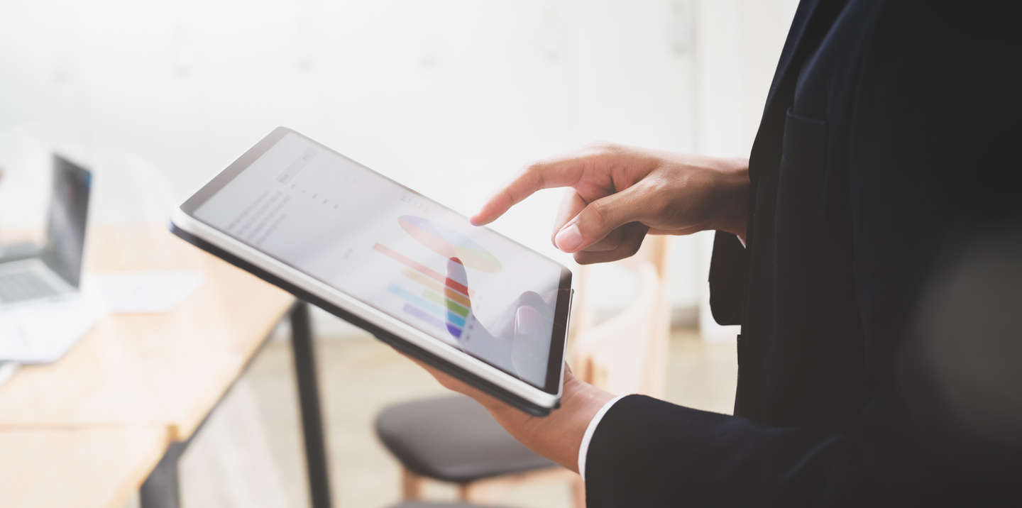 Crop executive designer analyzing data using graphics tablet in office